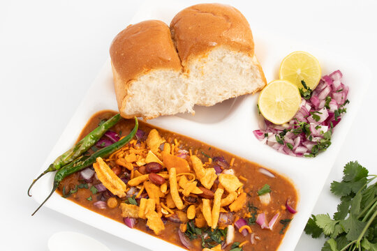 Misal Pav Or Usal Paav Is Famous Maharashtrian Spiced Street Dish. Buns are Served With Spicy Hot Curry Made Of Sprouts Moong Lentils Vegetables, Tomato Onion Grind Paste Puree, Farsan Namkeen Mixture