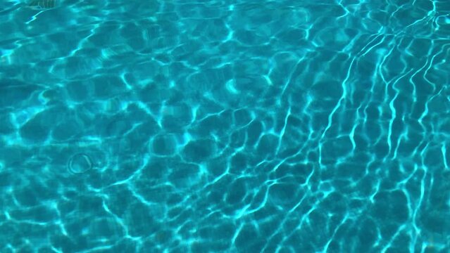 Pure blue water in the pool with light reflections. abstract background