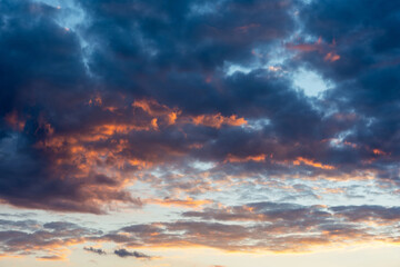 Naklejka na ściany i meble Colorful sunset clouds with fiery red cloud
