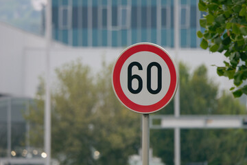 Selective focus shot of a Maximum Speed Limit 60 Street Sign with a blurry background