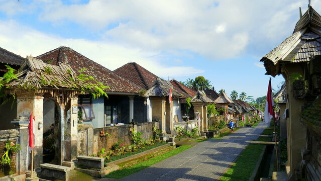 Hauptstra&szlig;e durch das Museumsdorf Penglipuran in Bali mit alten traditionellen H&auml;usern und Palmen