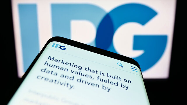 Stuttgart, Germany - 08-27-2022: Mobile phone with webpage of Interpublic Group of Companies Inc. (IPG) on screen in front of business logo. Focus on top-left of phone display.