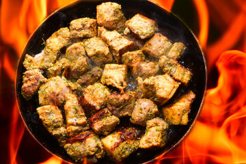 pork meat is cooked on fire
