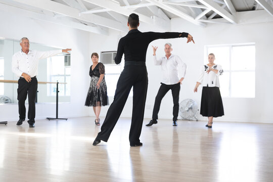 Mixed race dance teacher demonstrating ballroom dancing