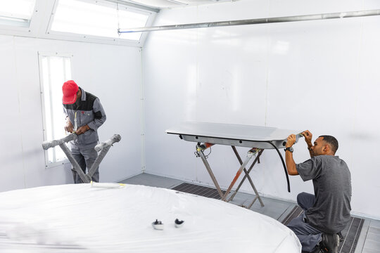 Multi races mechanics preparing painting car session - Powered by Adobe