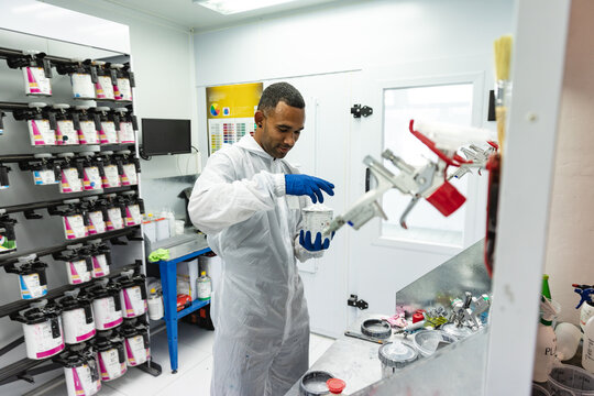 Mixed race car painter preparing his painting - Powered by Adobe