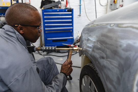 African American mechanic man working on a car