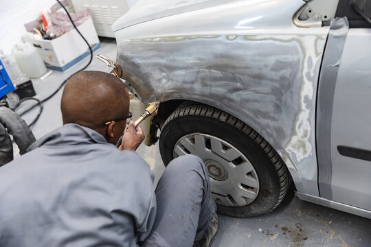 African American mechanic man working on a car