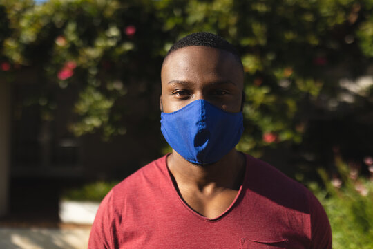 Portrait of african american man wearing face mask in the garden
