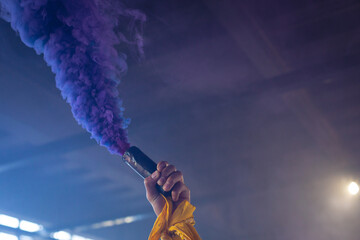 Mixed race woman in an empty building holding a purple flare