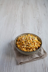 Homemade Slow Cooker Creamed Corn in a Bowl, side view. Space for text.