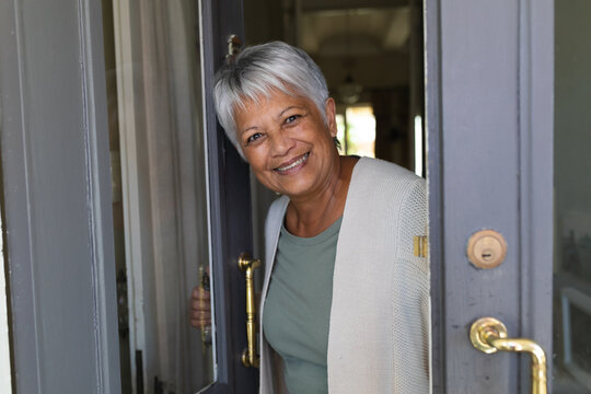 Portrait of senior african american woman standing in door looking at camera and smiling