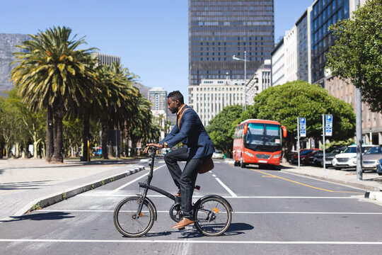 African american man riding a bicycle crossing the road