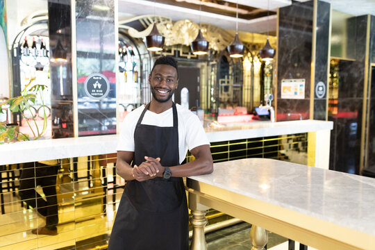 Portrait of african american male barista looking at the camera and smiling