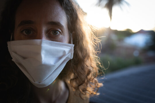 Woman wearing a face mask at home. Social distancing in quarantine during coronavirus epidemic