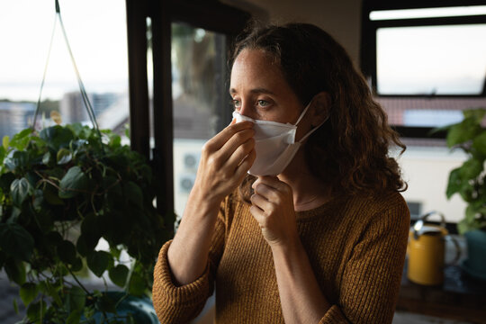 Woman wearing a face mask at home. Social distancing in quarantine during coronavirus epidemic