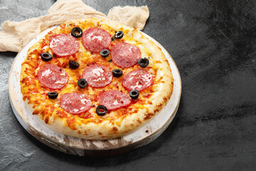 Freshly baked pepperoni pizza on dark background.