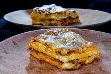 Lasagna or lasagne Bolognese on a wooden dish