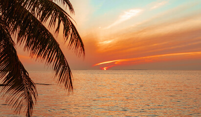 picturesque sunrise in the Maldives island, the sun rising from the Indian ocean and reflected in...