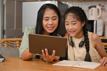 Portrait image of Mom and daughter using tablet for online learning, Coronavirus pandemic forces children, Online learning concept.