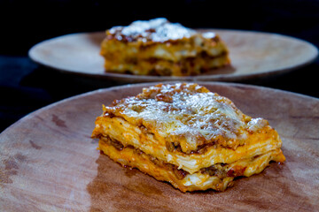 Lasagna or lasagne Bolognese on a wooden dish