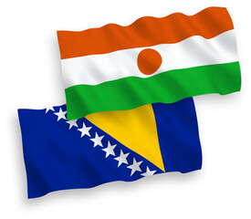 National vector fabric wave flags of Republic of the Niger and Bosnia and Herzegovina isolated on white background. 1 to 2 proportion.