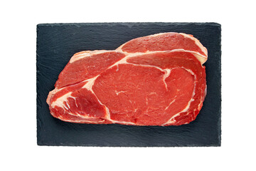 Juicy raw meat cut. Beef entrecote slice on the black textured slate plate isolated transparent png top view. 