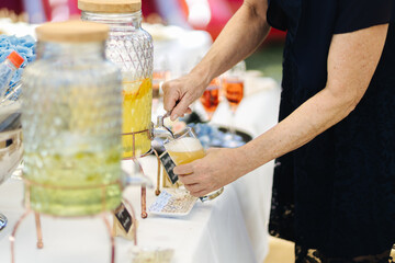 Jars with Alcoholic beverages at a wedding. Glasses and drinks at an event.