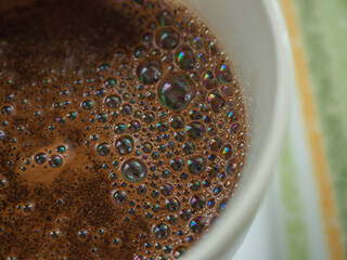 Kawa w kubku na talerzyku z zielonym paskiem