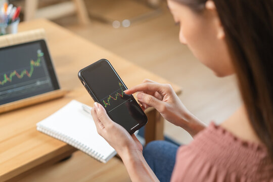 Investor analyzing exchange market, asian young business woman, girl trader on graphic charts on tablet, smartphone for trading stock, looking at screen with diagrams at home office. Start up people.