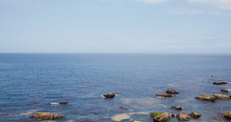 Sea water wave over the rock and stone beach