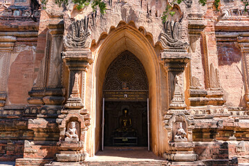 A Buddha statue in a Burmese temple with many decorations with clear sky in Bagan, Myanmar