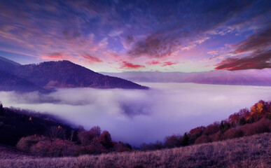 Morning in the mountains. A wonderful autumn landscape. Blue morning sky, sun rays and morning fog.