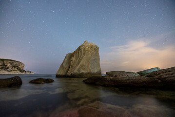 Sail rocks, sail shaped rocks on aegean seawith clouds and sunset colors and stars