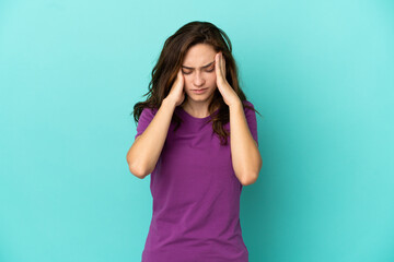 Young caucasian woman isolated on blue background with headache