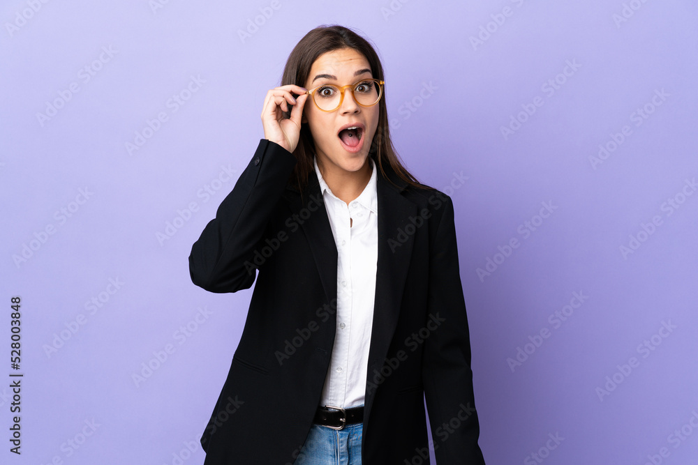 Wall mural Business woman isolated on purple background with glasses and surprised