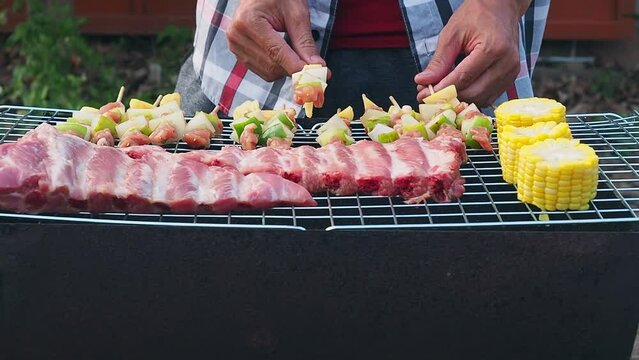 A man grilling barbecue and pork ribs in dinner party. Food, people freind and family time concept.