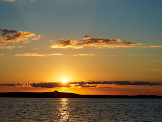 Fototapeta na wymiar Beautiful sunset. Sunset over the water. The sun sets over a large lake.