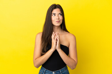 Young Brazilian woman isolated on yellow background scheming something