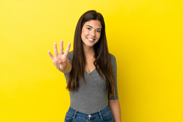 Young Brazilian woman isolated on yellow background happy and counting four with fingers