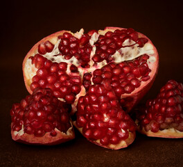 red pomegranate fruit lies on a dark background