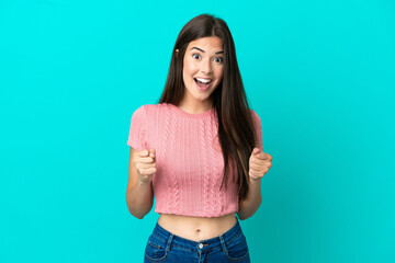 Young Brazilian woman isolated on blue background celebrating a victory in winner position