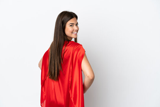 Young Brazilian Woman Isolated On White Background In Superhero Costume And Doingposing With Arms At Hip And Smiling