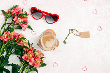 Bouquet of Alstroemeria flowers, cup of coffee, sunglasses and key with tag on a white marble...