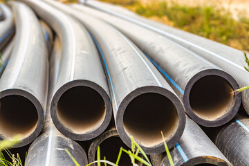 Water pipes for drinking water supply lie on the construction site. Preparation for earthworks for laying an underground pipeline. Modern water supply systems for a residential city.