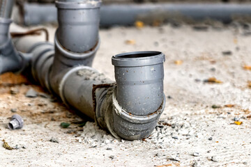 Sewer pipes in home basement. System of gray sanitary pipes when building a house. Sewer...