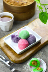 Mochi cakes one of Japanese traditional rice cake. Assorted color with different filling. Selective focus, grey grainy background.
