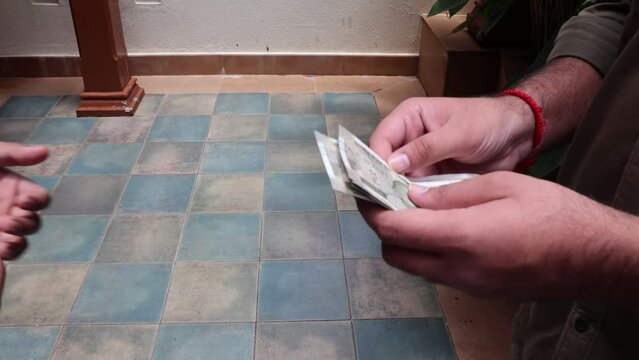 Shot of transaction of 2 parties exchanging denomination of Indian rupees. Close up of hand counting Indian Money. 4K video. New Indian currency notes. 500 Indian Rupee notes. paying in cash.