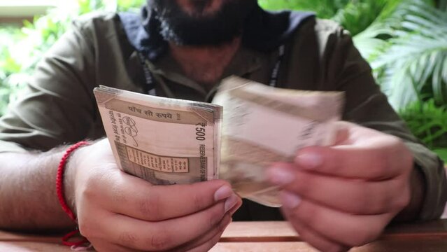 Front Shot of Indian male Counting multiple denomination of Indian rupees. Close up of hand counting Indian Money. 4K video. New Indian currency notes. 500 Indian Rupee notes. 