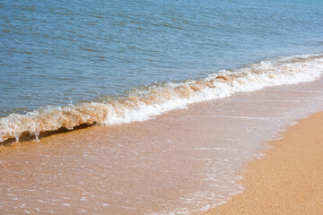 The coast of the Sea of Azov. Sea waves roll on the sandy shore. Seashell sandy beach.